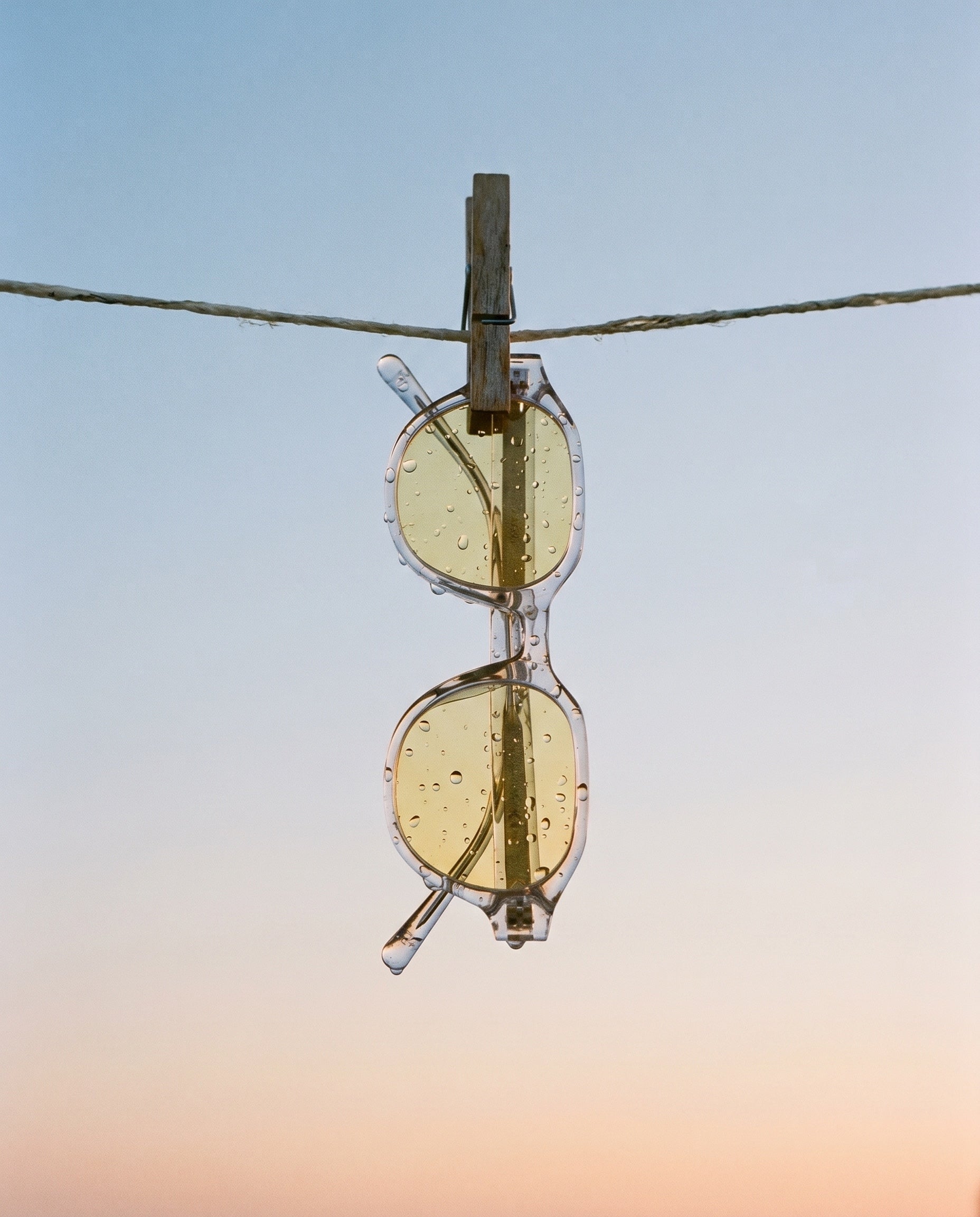 clear yellow sunglasses waterdrops clothesline sky_4x5